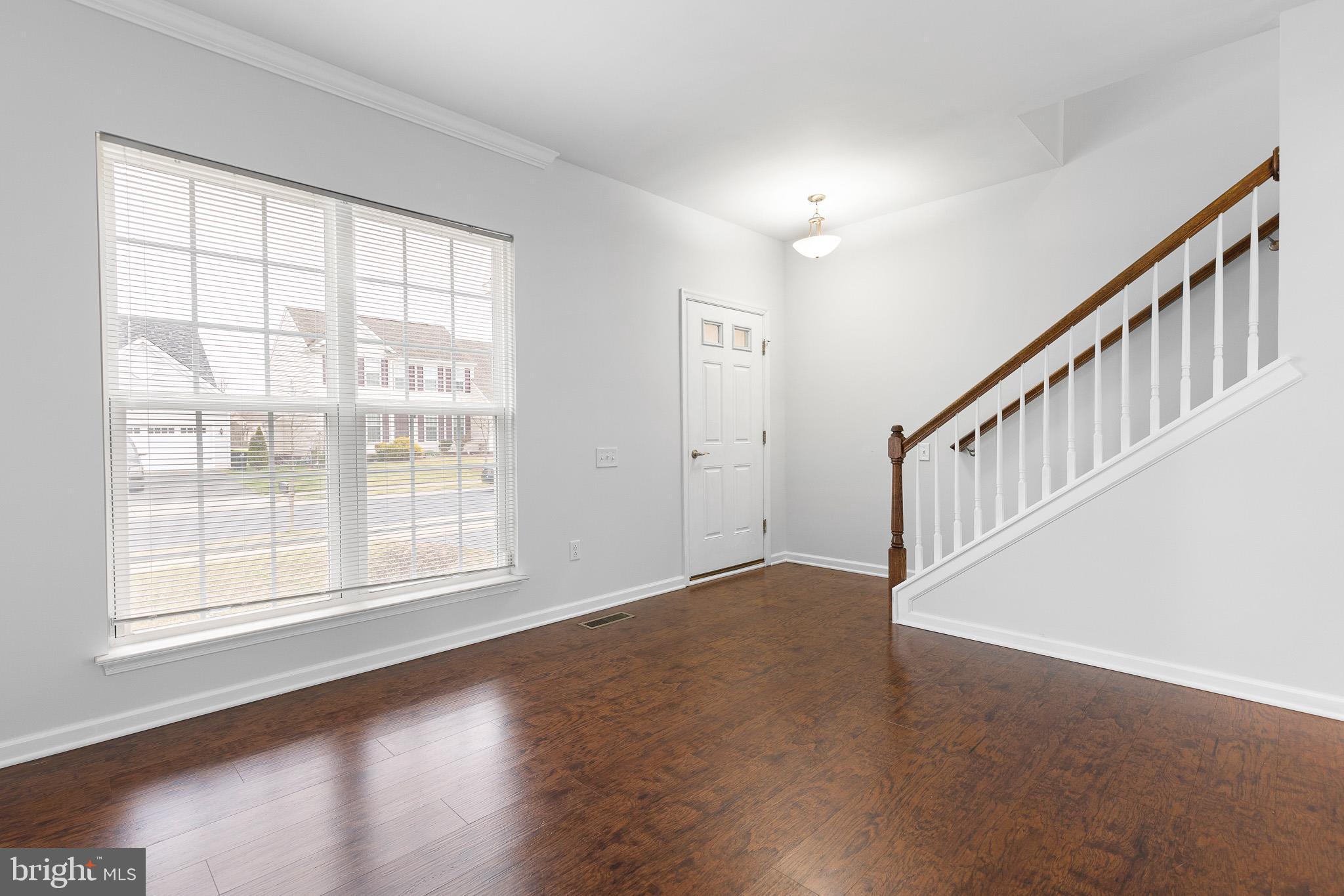 413 Janets Way Townsend, DE 19734 - Photo 2 of 27 a view of an empty room with wooden floor and windows