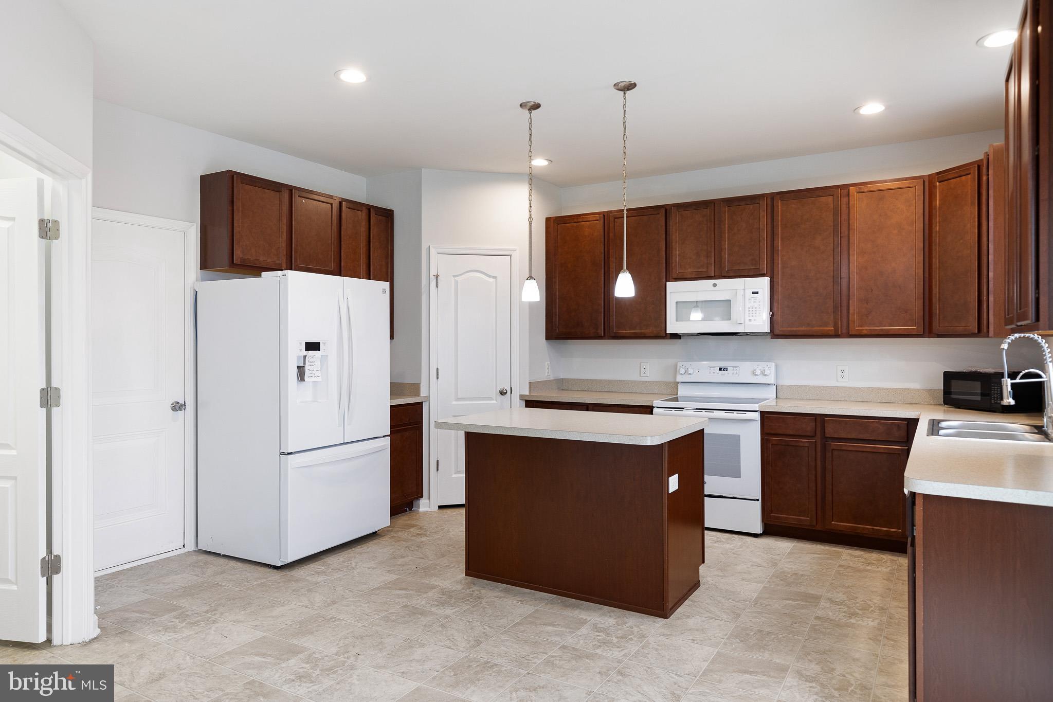 413 Janets Way Townsend, DE 19734 - Photo 5 of 27 a kitchen with stainless steel appliances a refrigerator a sink a stove a microwave a center island and cabinets