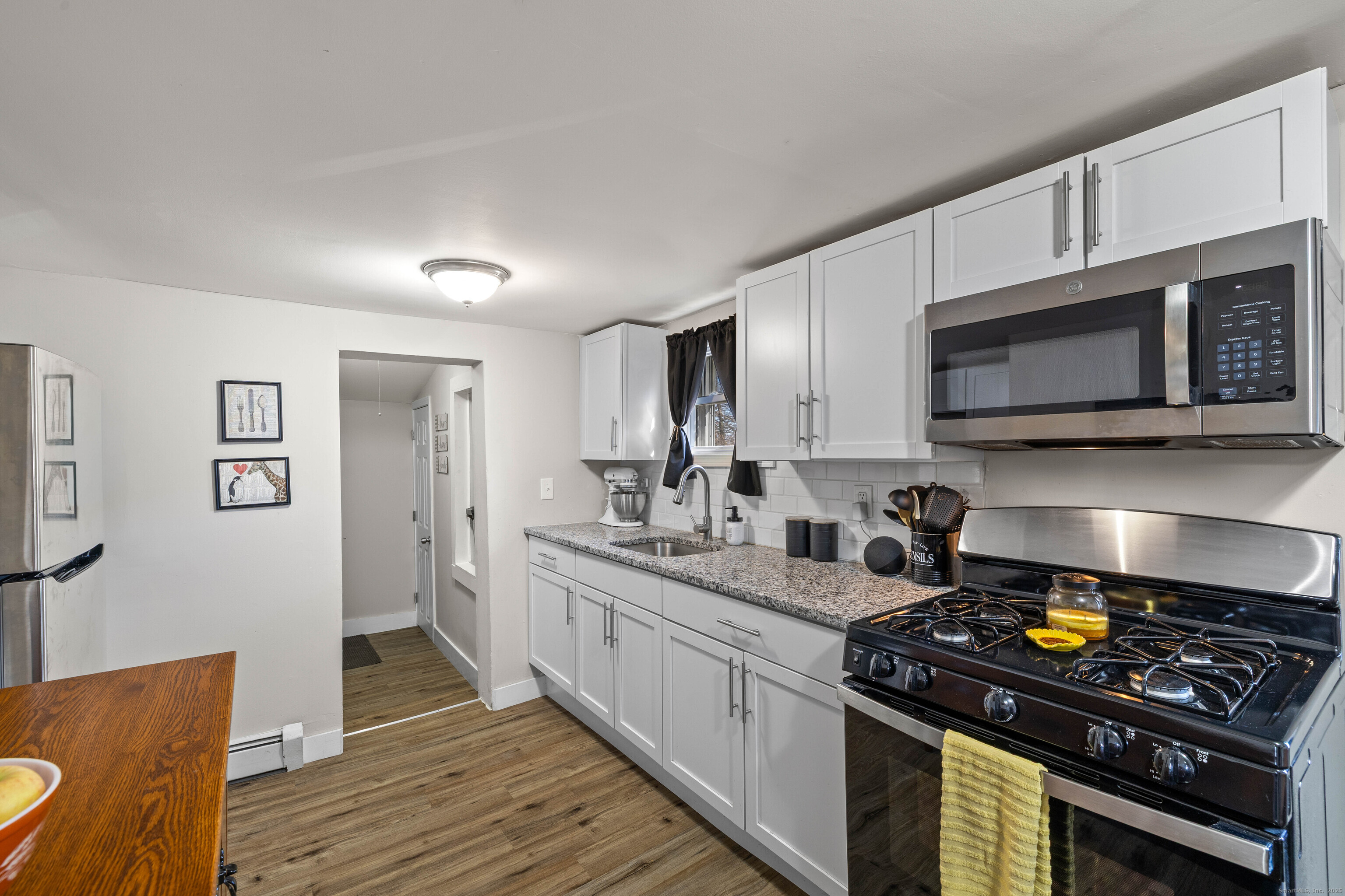 a kitchen with stainless steel appliances granite countertop a stove a sink and a microwave