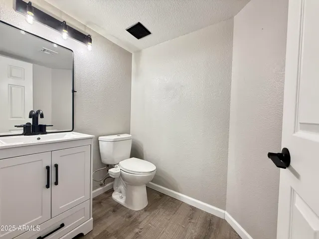 a bathroom with a toilet sink a mirror and vanity