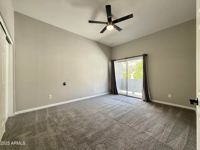 an empty room with closet and windows