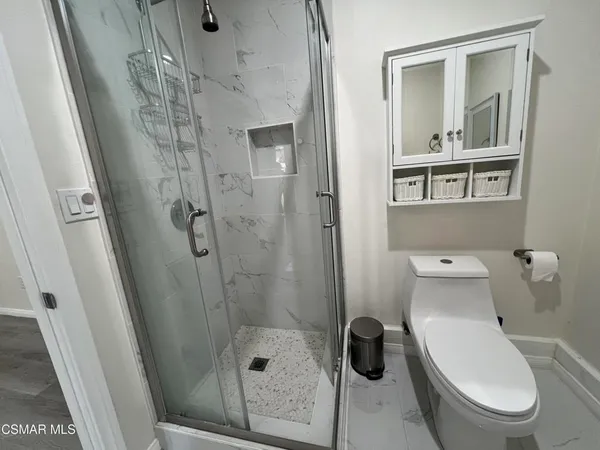 a bathroom with a toilet and a shower