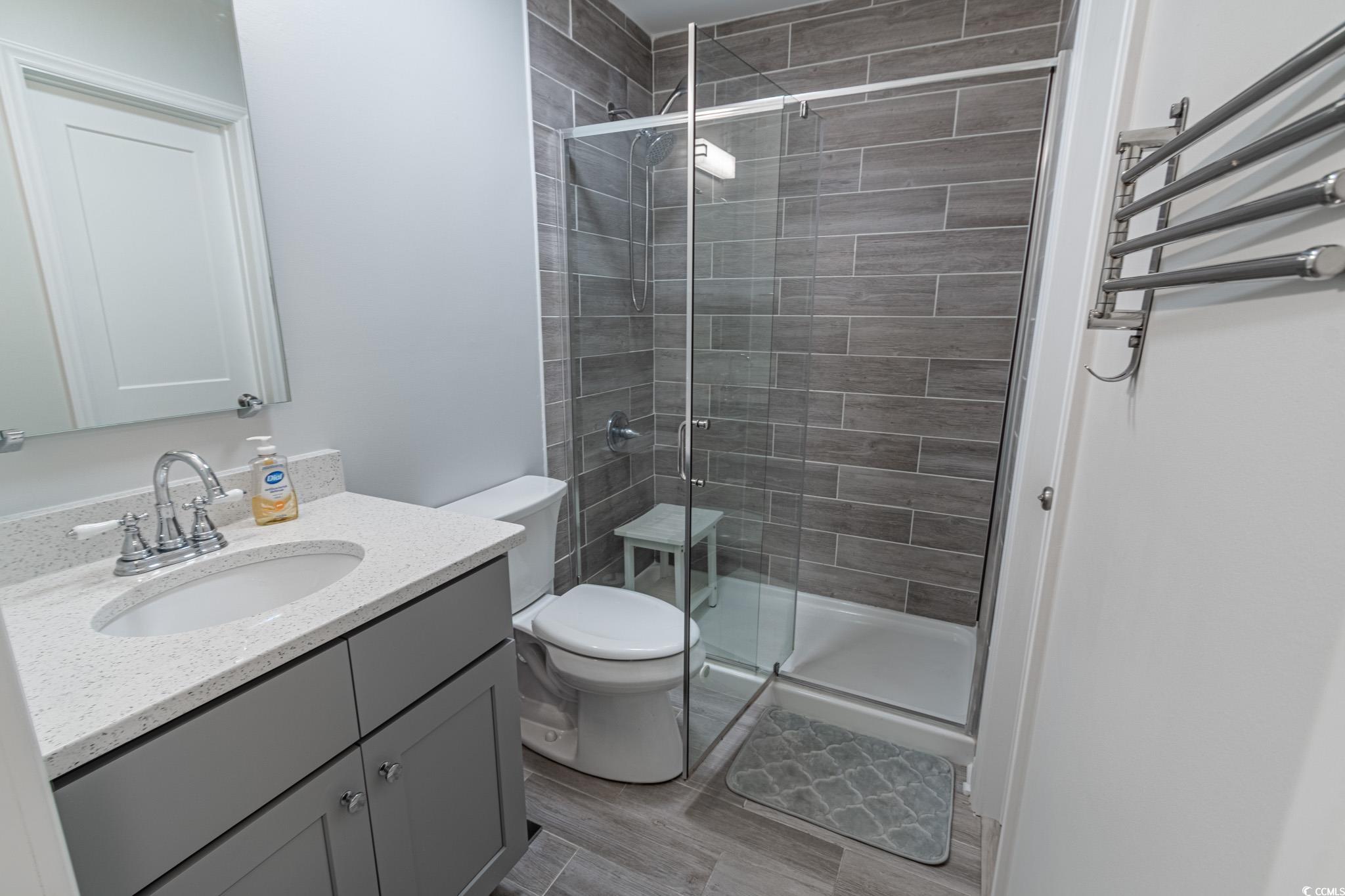 1210 North Ocean Boulevard, Unit 203 Surfside Beach, SC 29575 - Photo 14 of 27 Full bath featuring vanity, a stall shower, and light wood-style floors
