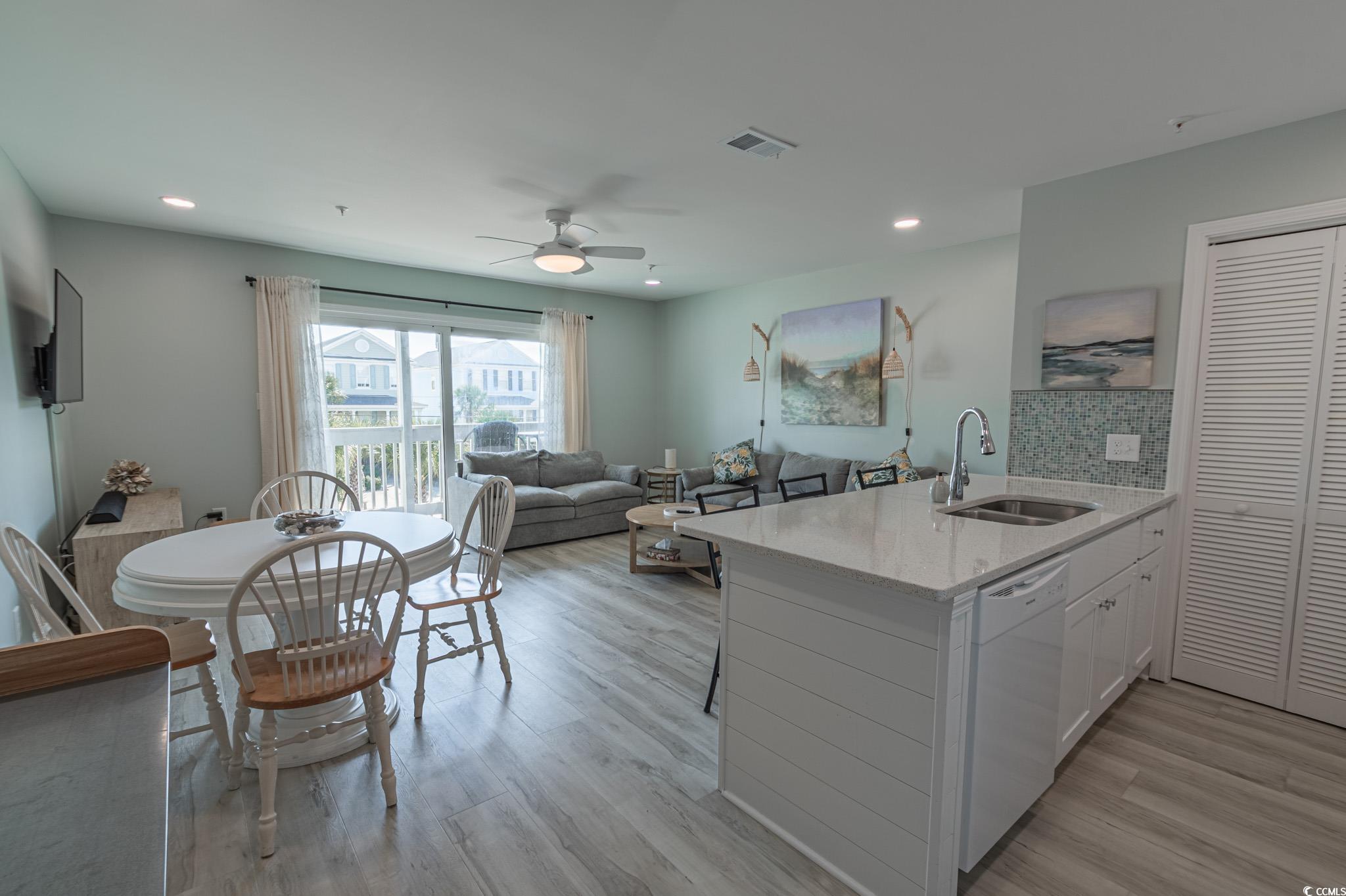 1210 North Ocean Boulevard, Unit 203 Surfside Beach, SC 29575 - Photo 5 of 27 Kitchen featuring a peninsula, light stone counters, tasteful backsplash, white cabinetry, and a ceiling fan