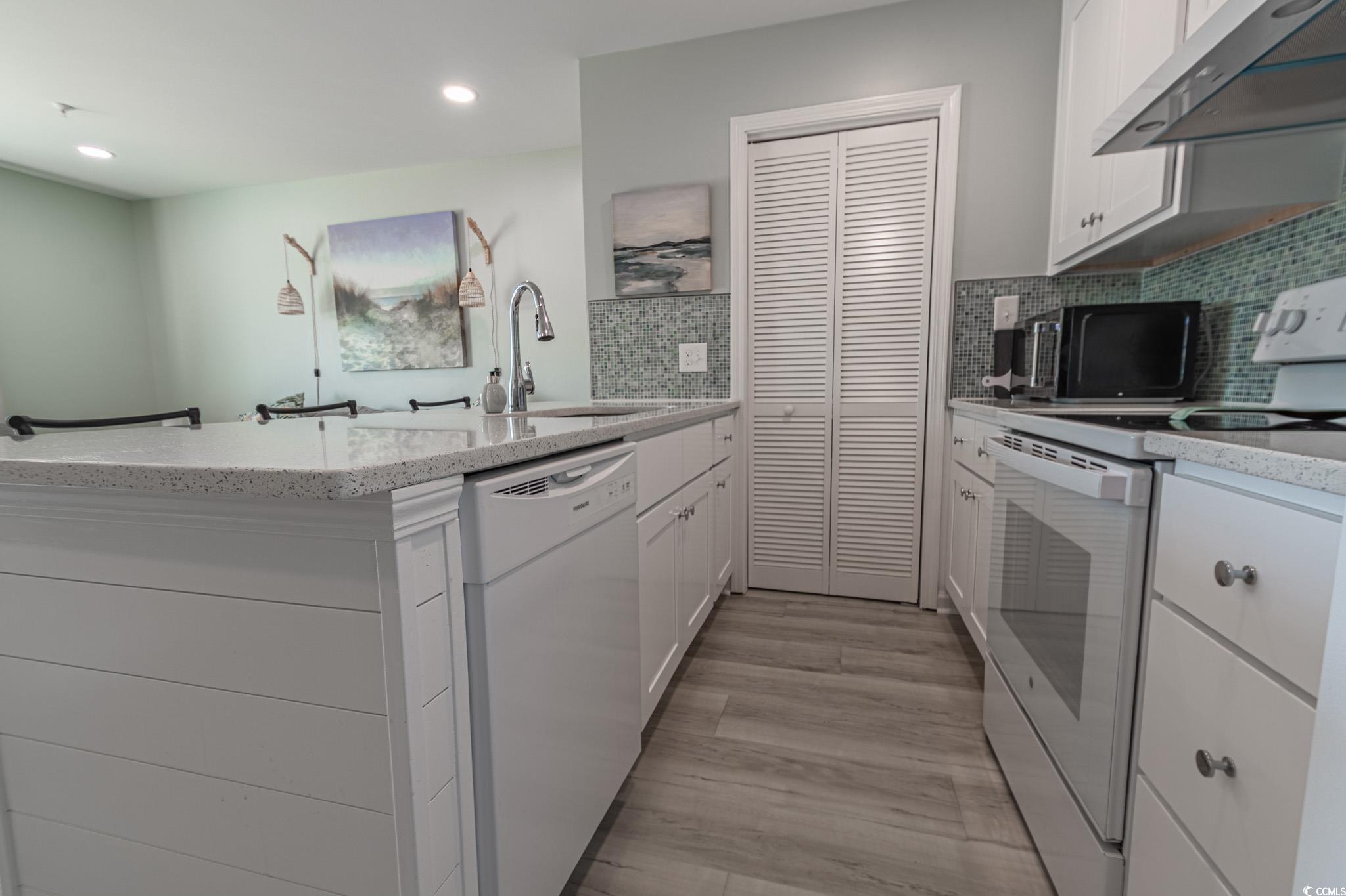 1210 North Ocean Boulevard, Unit 203 Surfside Beach, SC 29575 - Photo 7 of 27 Kitchen featuring white appliances, white cabinets, tasteful backsplash, under cabinet range hood, and recessed lighting