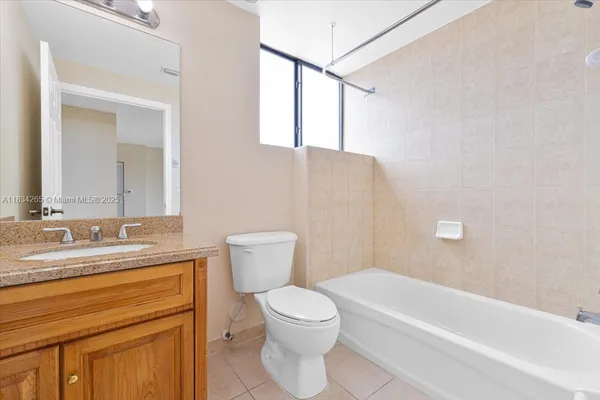 a bathroom with a granite countertop sink a toilet and bathtub