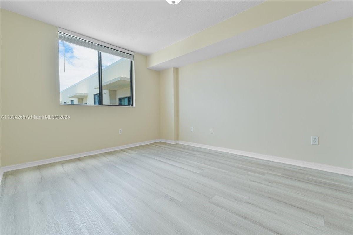 4242 Northwest 2nd Street, Unit 1601 Miami, FL 33126 - Photo 12 of 37 an empty room with wooden floor and windows