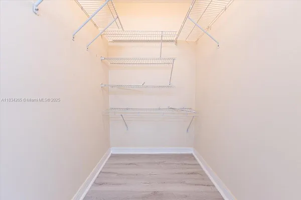 a view of walk in closet with empty racks