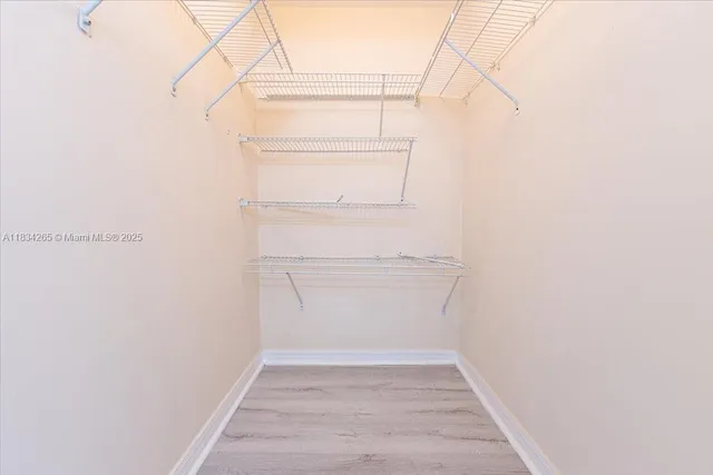 a view of walk in closet with empty racks