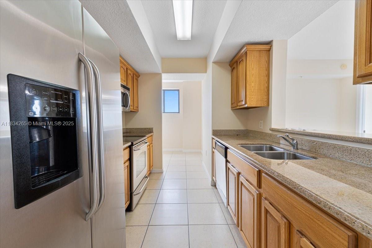 4242 Northwest 2nd Street, Unit 1601 Miami, FL 33126 - Photo 18 of 37 a kitchen with a sink stove and refrigerator