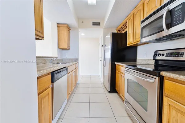 a kitchen with stainless steel appliances granite countertop a stove a sink and a microwave