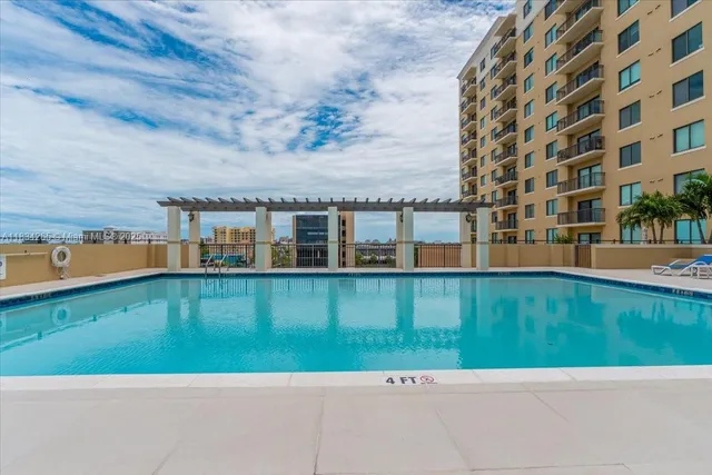 a front view of a house with a garden and lake view