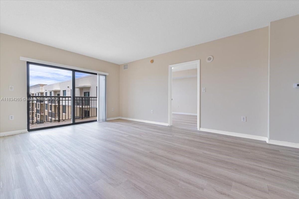 4242 Northwest 2nd Street, Unit 1601 Miami, FL 33126 - Photo 4 of 37 a view of an empty room with wooden floor and a window