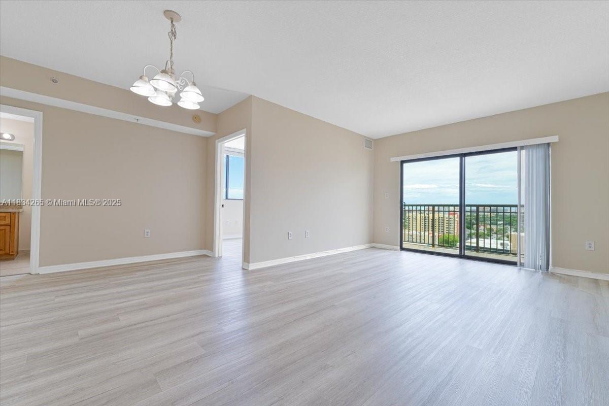 4242 Northwest 2nd Street, Unit 1601 Miami, FL 33126 - Photo 6 of 37 a view of an empty room with wooden floor and a window