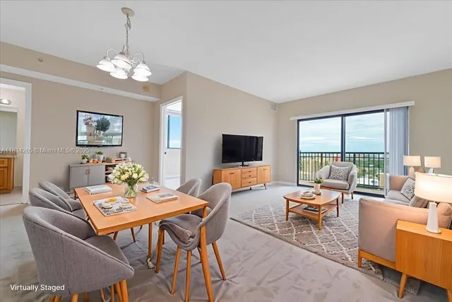 a living room with furniture a flat screen tv and a large window
