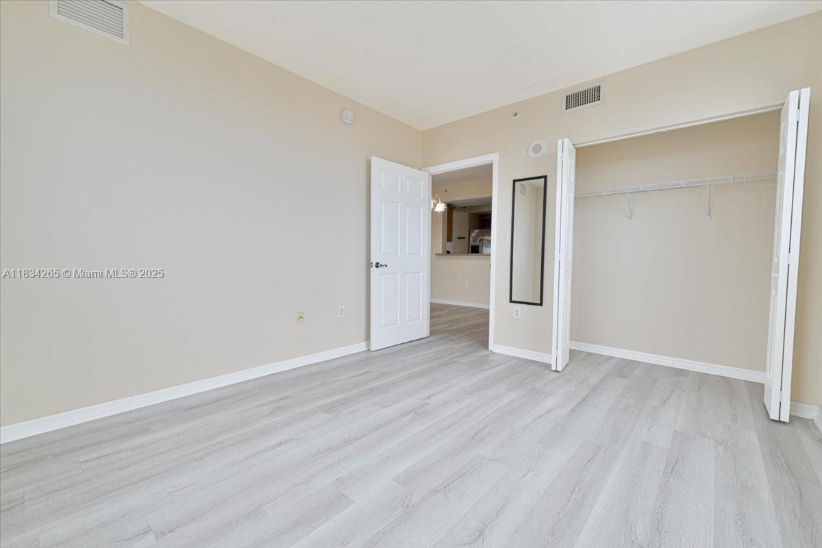 4242 Northwest 2nd Street, Unit 1601 Miami, FL 33126 - Photo 8 of 37 an empty room with wooden floor & closet and windows