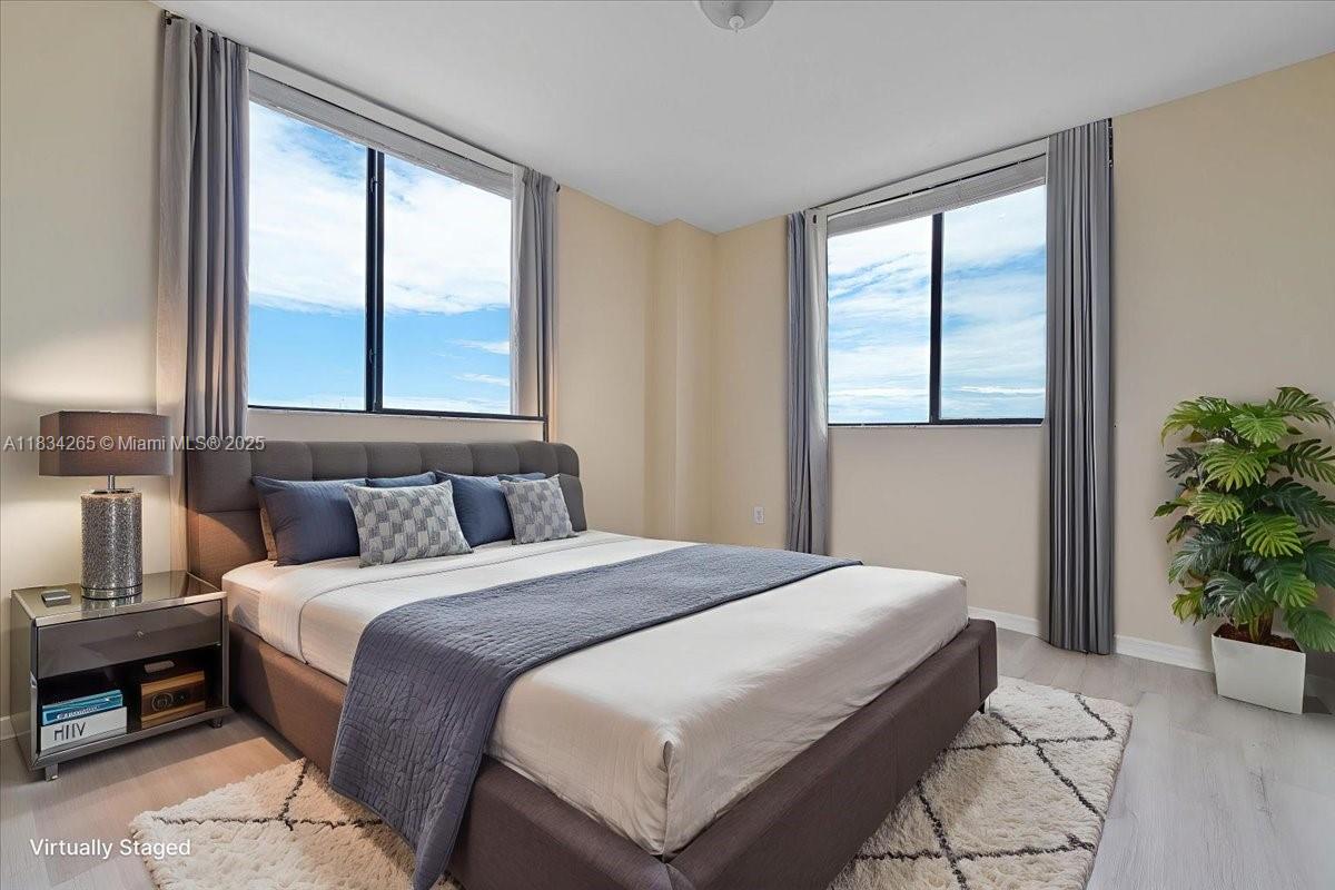 4242 Northwest 2nd Street, Unit 1601 Miami, FL 33126 - Photo 10 of 37 a bedroom with a large bed and a potted plant