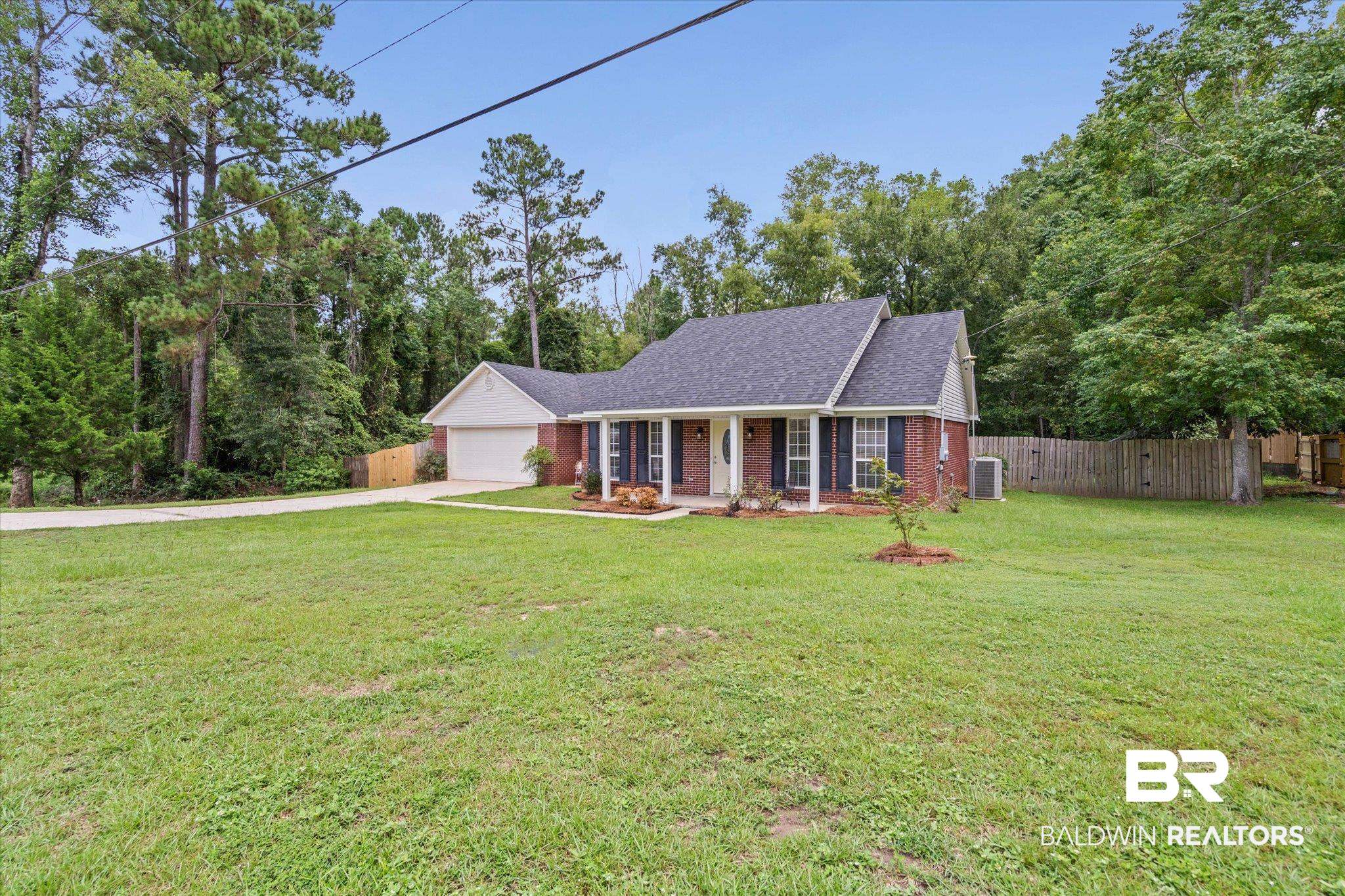 157 Bay View Drive Daphne, AL 36526 - Photo 19 of 22 View of front of house featuring covered porch, an attached garage, driveway, brick siding, and a shingled roof