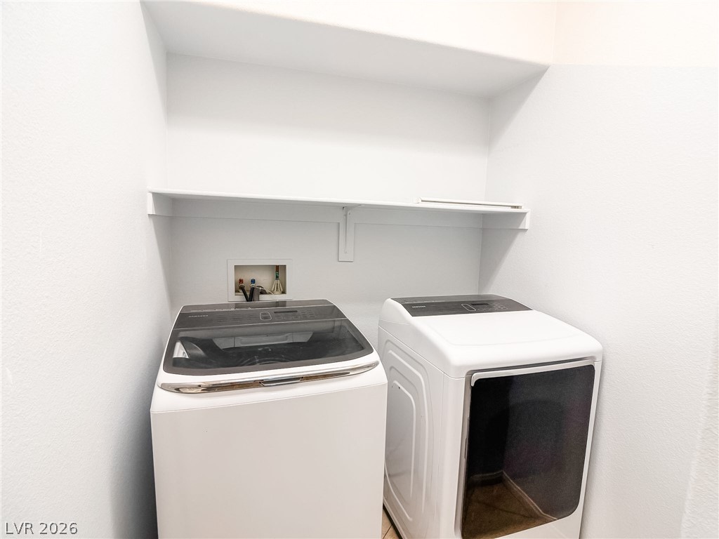 8683 Moreno Mountain Avenue Las Vegas, NV 89178 - Photo 11 of 26 A dedicated laundry space provides ample room for appliances and storage shelves.