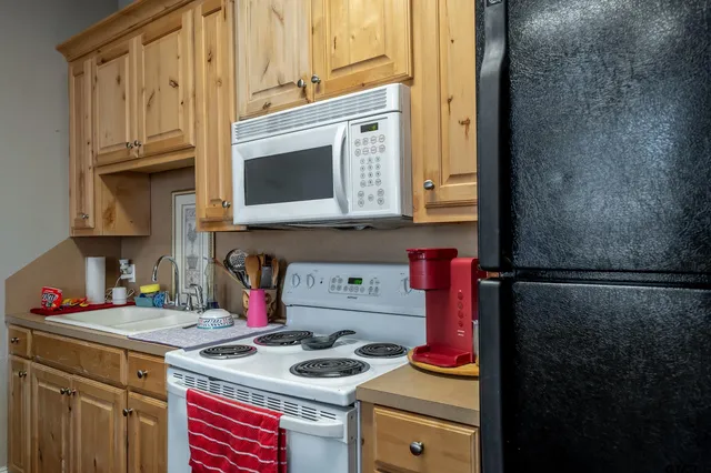 a kitchen with stainless steel appliances granite countertop a stove a refrigerator and a microwave