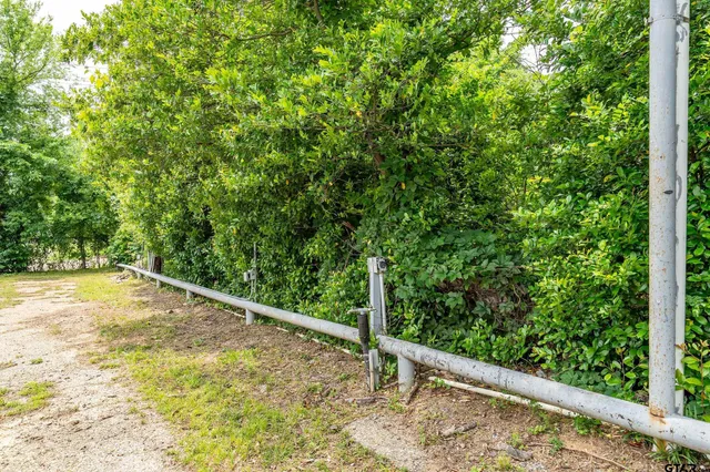 a view of a yard with wooden fence