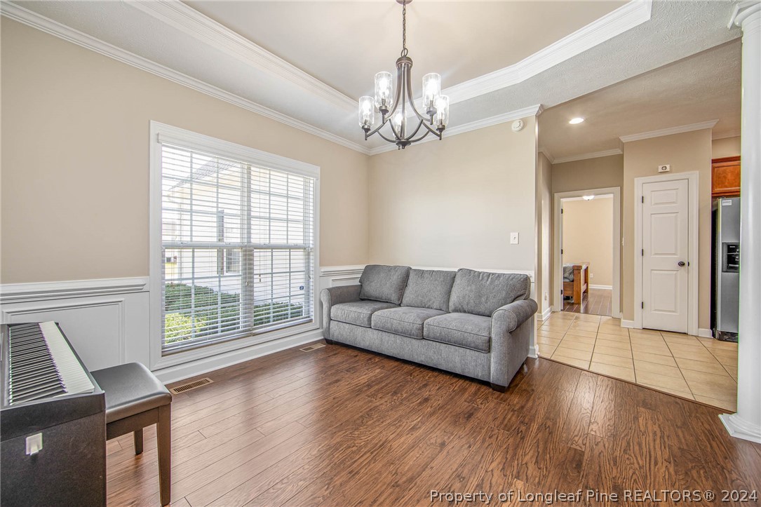 3304 Geyser Peak Road Fayetteville, NC 28306 - Photo 11 of 39 a living room with furniture and a chandelier