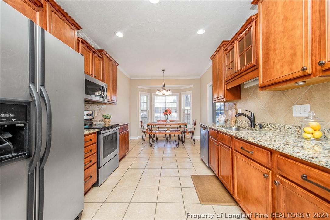 3304 Geyser Peak Road Fayetteville, NC 28306 - Photo 13 of 39 a kitchen with stainless steel appliances granite countertop a refrigerator a sink dishwasher a stove and white countertops with wooden floor
