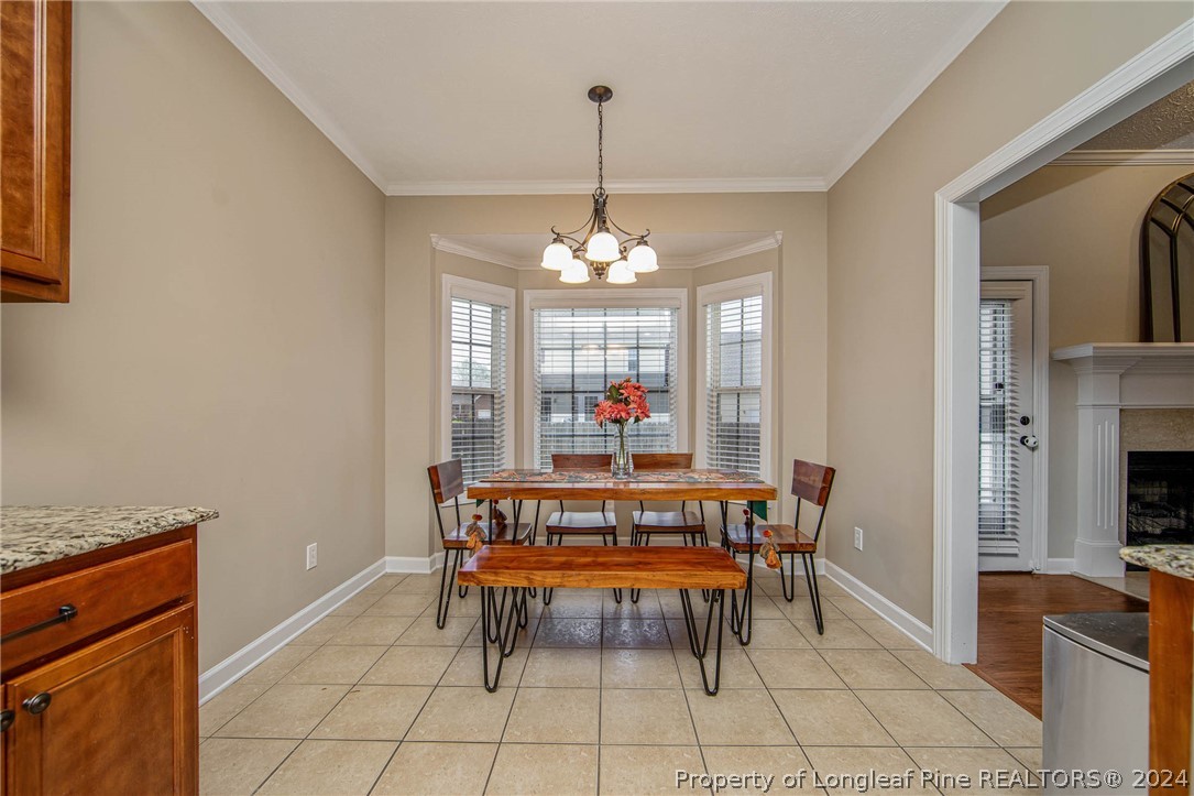 3304 Geyser Peak Road Fayetteville, NC 28306 - Photo 16 of 39 a dining room with furniture a chandelier and a rug