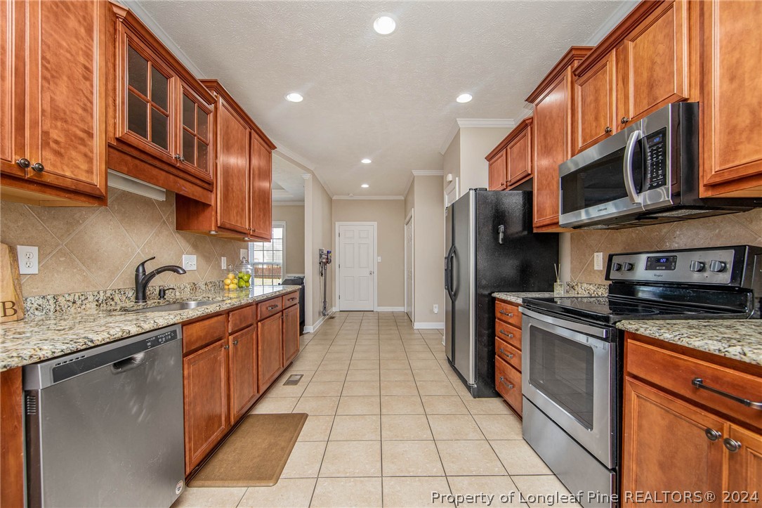 3304 Geyser Peak Road Fayetteville, NC 28306 - Photo 17 of 39 a kitchen with stainless steel appliances granite countertop a stove a sink and a microwave