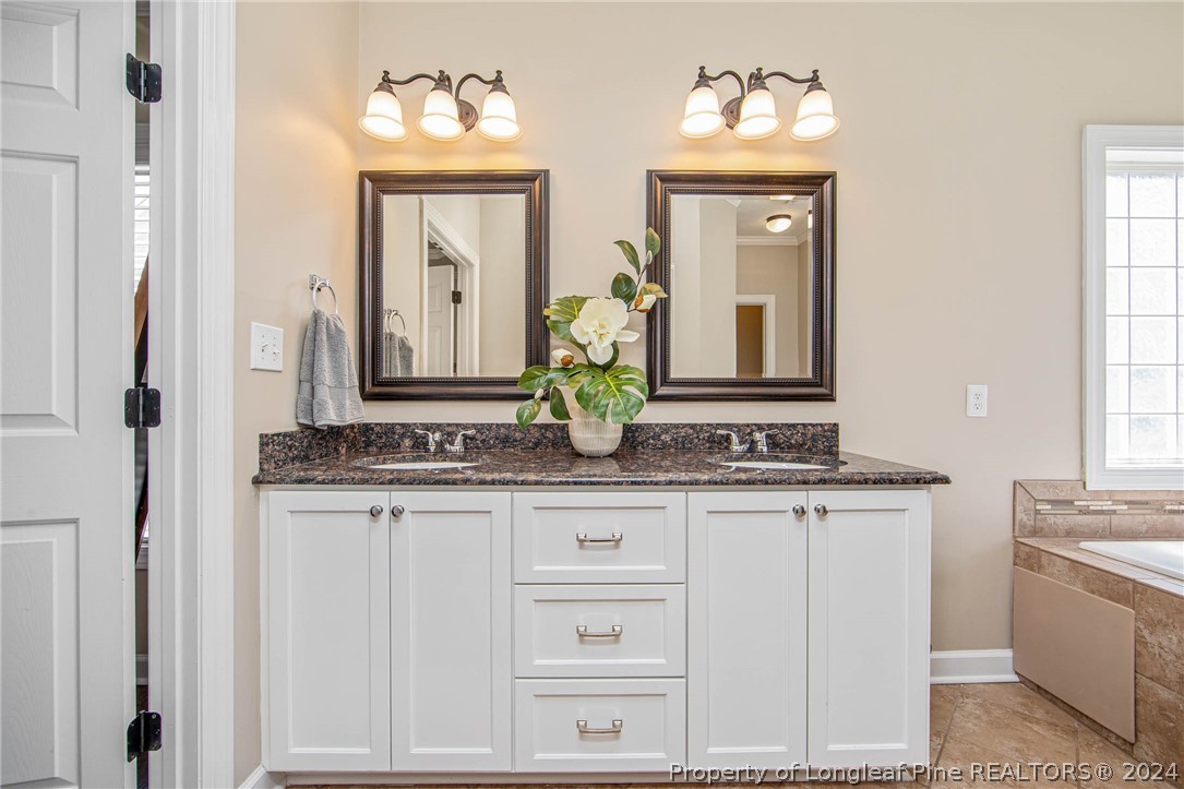 3304 Geyser Peak Road Fayetteville, NC 28306 - Photo 23 of 39 a bathroom with a granite countertop sink and a mirror