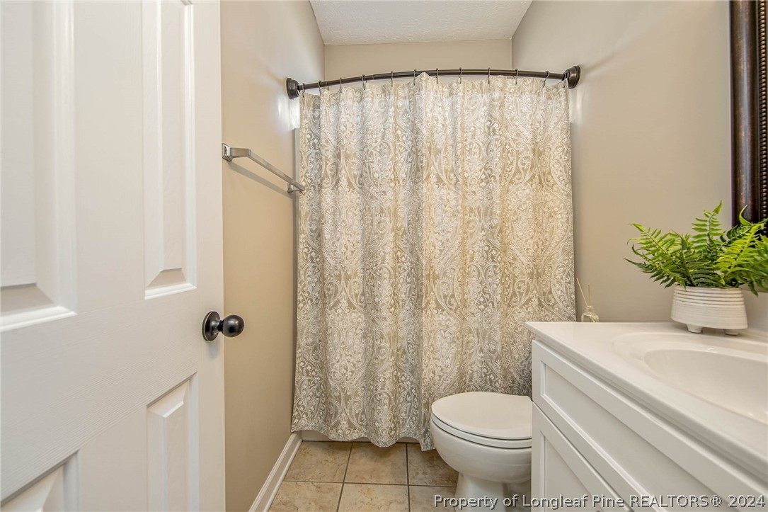 3304 Geyser Peak Road Fayetteville, NC 28306 - Photo 28 of 39 a white toilet sitting next to a shower curtain