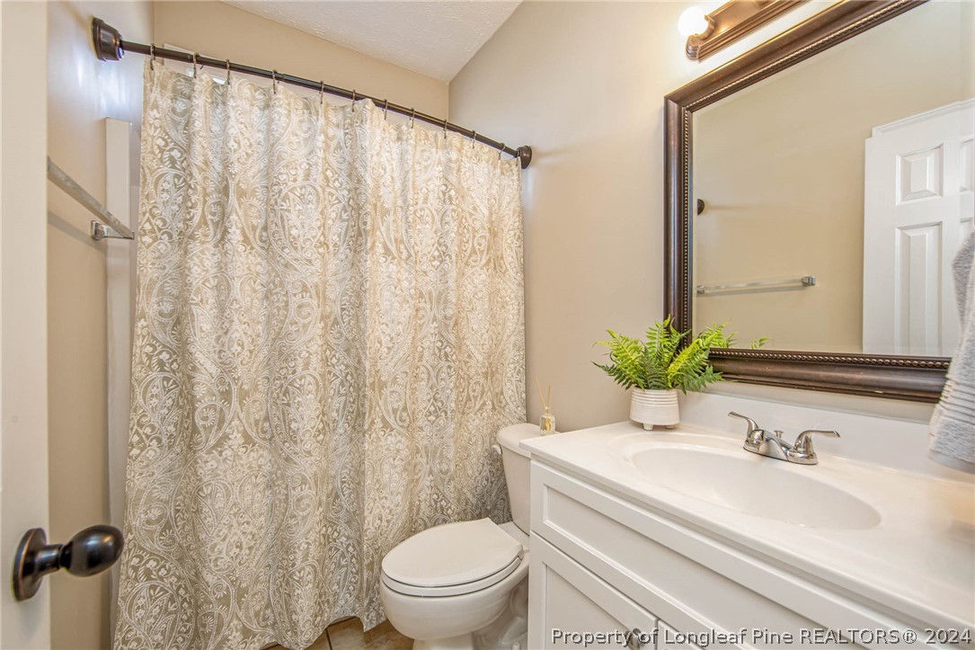 3304 Geyser Peak Road Fayetteville, NC 28306 - Photo 29 of 39 a bathroom with a granite countertop sink toilet and mirror
