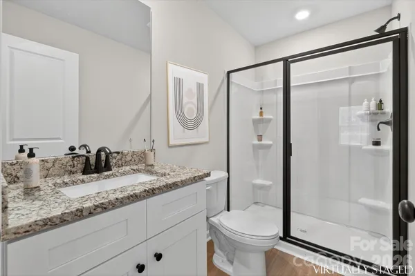 a bathroom with a granite countertop sink toilet and shower
