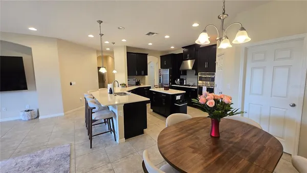 a kitchen with a dining table chairs and a chandelier