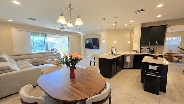 a kitchen with stainless steel appliances kitchen island granite countertop a sink dishwasher a dining table and chairs