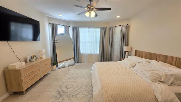a bedroom with a bed couch and a flat screen tv