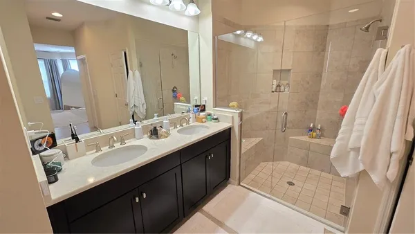 a bathroom with a double vanity sink mirror double and shower