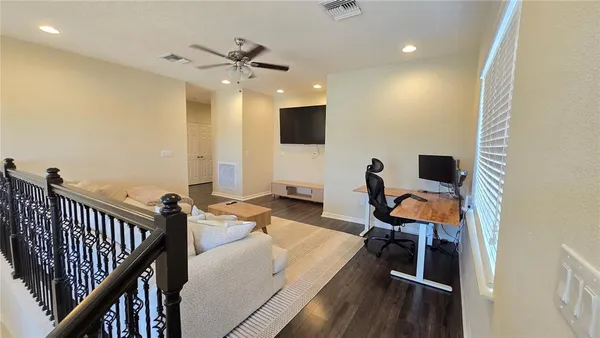 a view of a workspace with furniture and a window