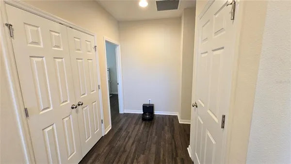 a view of a hallway with wooden floor and staircase