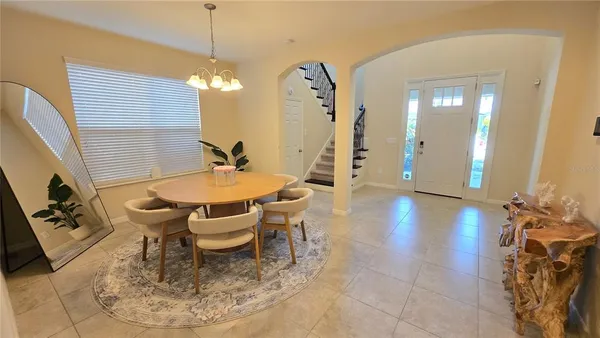 a dining room with furniture a chandelier and wooden floor