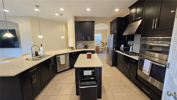a kitchen with kitchen island granite countertop stainless steel appliances and sink