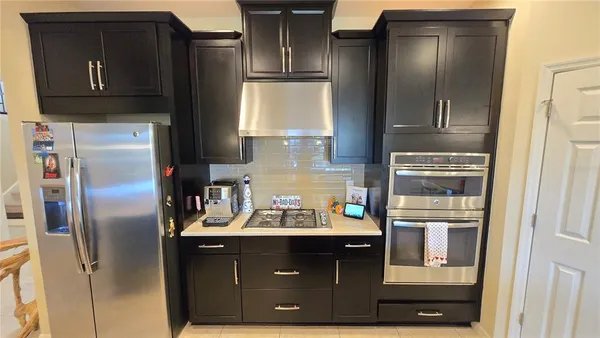 a kitchen with stainless steel appliances granite countertop a refrigerator and a stove