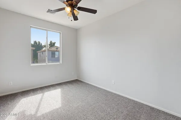 an empty room with closet and windows