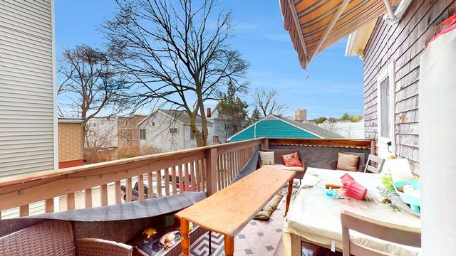a balcony with wooden floor table and chairs