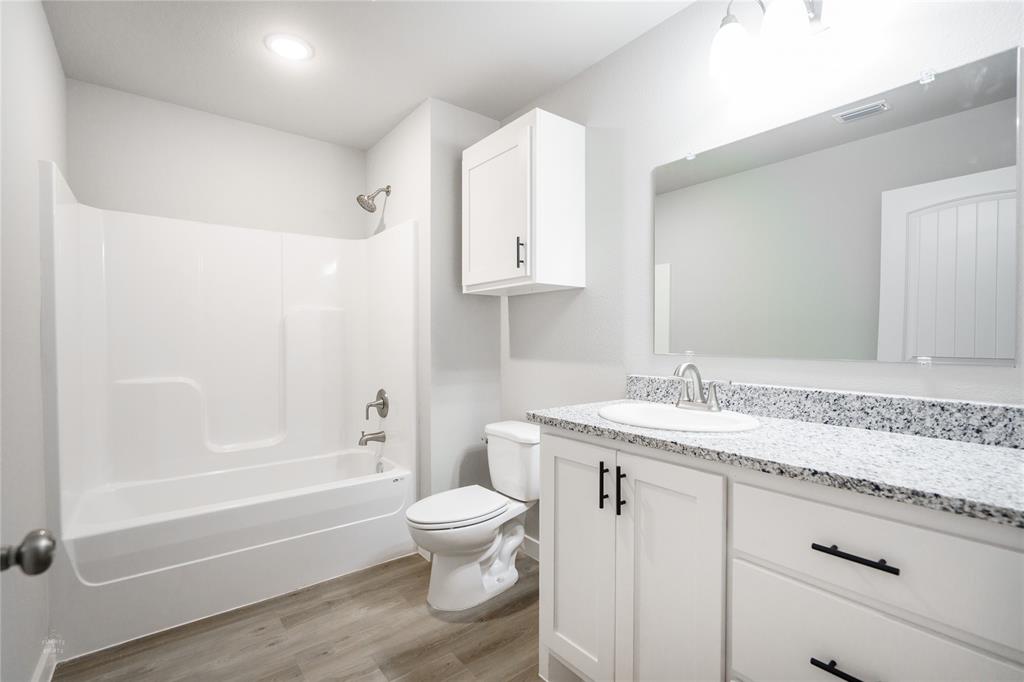 2610 Roman Lane Abilene, TX 79606 - Photo 13 of 17 a bathroom with a granite countertop sink a toilet and bathtub