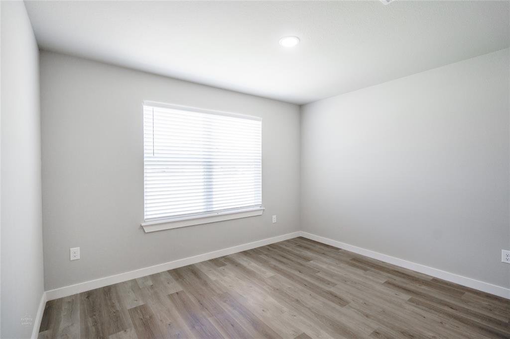 2610 Roman Lane Abilene, TX 79606 - Photo 15 of 17 an empty room with wooden floor and windows