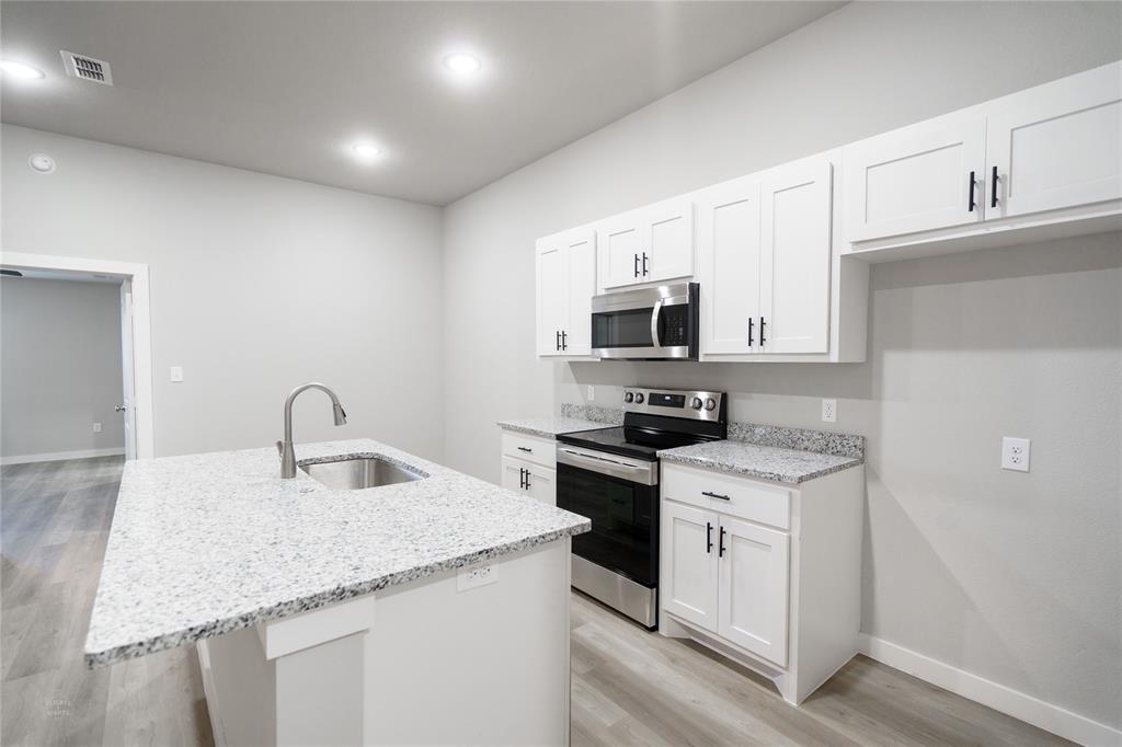 2610 Roman Lane Abilene, TX 79606 - Photo 8 of 17 a kitchen with stainless steel appliances granite countertop a sink stove refrigerator and microwave