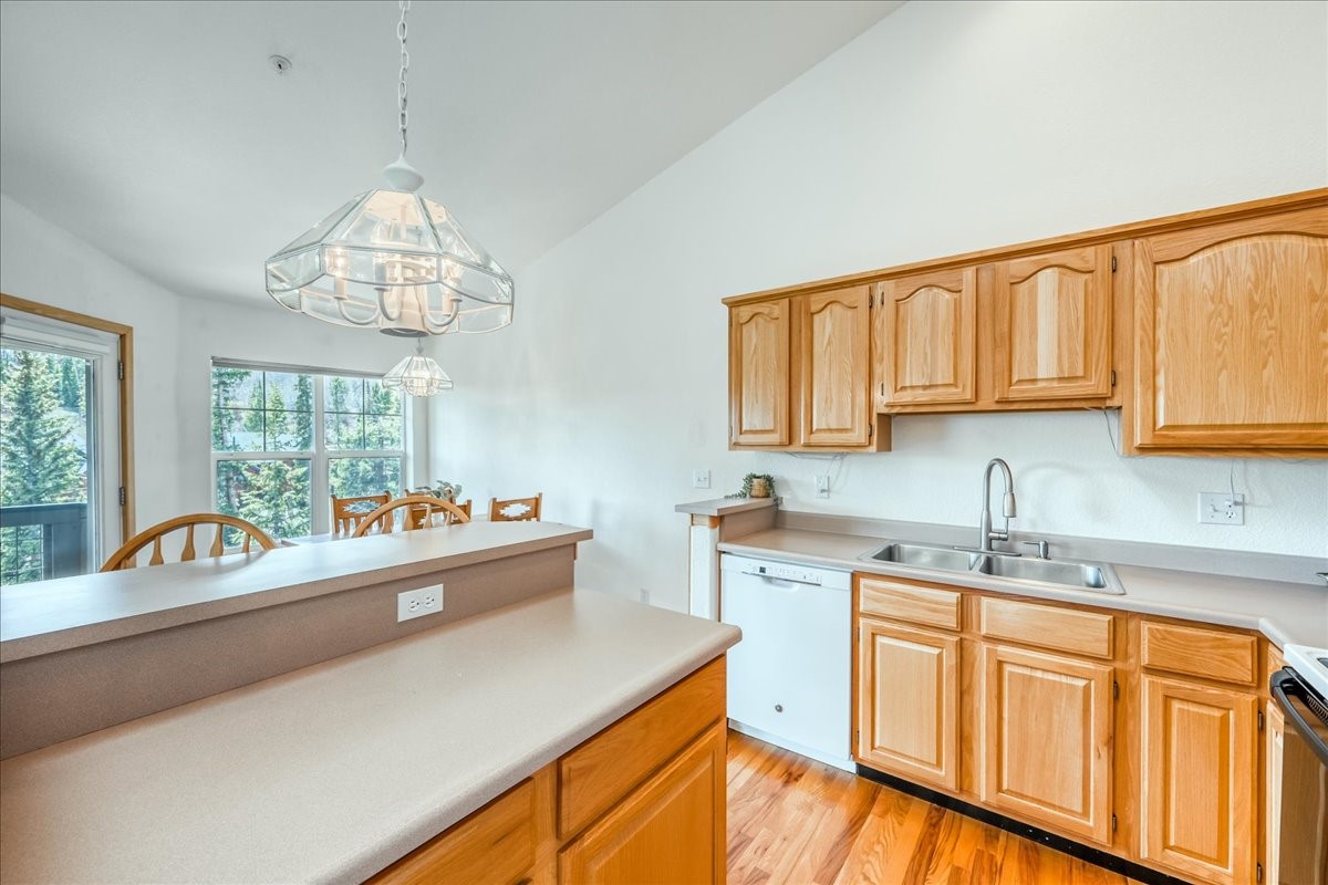 91399 Ryan Gulch Road, Unit B6 Silverthorne, CO 80498 - Photo 10 of 36 a kitchen with kitchen island granite countertop a sink cabinets and window