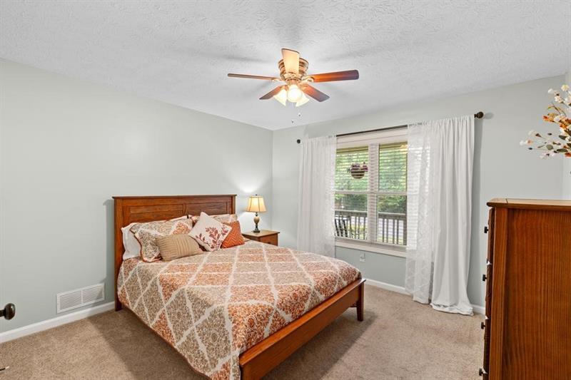 212 Wimberly Ridge McDonough, GA 30253 - Photo 16 of 44 a bedroom with a bed a window and a chandelier