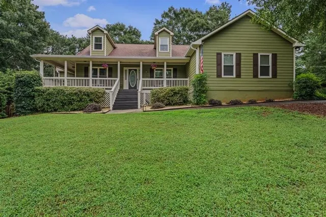 a front view of a house with a yard and green space